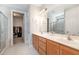 Bathroom with double vanity, large mirror, and doorway leading to a spacious walk-in closet at 210 Olde Liberty Dr, Youngsville, NC 27596
