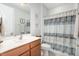 Bright bathroom with wood vanity, framed mirror, and patterned shower curtain at 210 Olde Liberty Dr, Youngsville, NC 27596