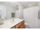 Clean bathroom featuring a single sink vanity, large mirror and shower with white curtain at 210 Olde Liberty Dr, Youngsville, NC 27596