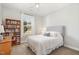 Cozy bedroom features a ceiling fan, natural light, and built-in bookshelf at 210 Olde Liberty Dr, Youngsville, NC 27596
