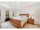 Bright bedroom featuring a wooden bed frame, neutral walls, and windows dressed with white blinds at 210 Olde Liberty Dr, Youngsville, NC 27596
