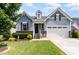 Charming two-story home with blue siding, brick accents, landscaped yard, and inviting front entrance at 210 Olde Liberty Dr, Youngsville, NC 27596