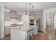 Stylish kitchen with granite island, stainless appliances, shaker cabinets, and hardwood floors at 210 Olde Liberty Dr, Youngsville, NC 27596