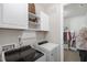 Well-lit laundry room with modern washer and dryer, storage cabinets, and access to closet at 210 Olde Liberty Dr, Youngsville, NC 27596