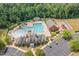 Aerial view of a pool and clubhouse area with playground and parking surrounded by mature trees at 210 Olde Liberty Dr, Youngsville, NC 27596