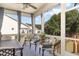 Screened porch with comfortable seating and blue skies and mature trees in the background at 210 Olde Liberty Dr, Youngsville, NC 27596