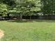 Spacious backyard featuring mature trees and a swing set at 211 Hillcrest Dr, Oxford, NC 27565