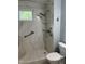 Updated bathroom shower with marble surround, grab bar, and handheld shower head at 211 Hillcrest Dr, Oxford, NC 27565