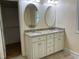 Bathroom featuring a double vanity with granite countertops and two oval mirrors at 211 Hillcrest Dr, Oxford, NC 27565
