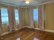 Bedroom featuring hardwood floors, neutral paint, a ceiling fan, and multiple windows at 211 Hillcrest Dr, Oxford, NC 27565
