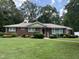 Charming brick home features mature landscaping, a well-manicured lawn, and inviting curb appeal at 211 Hillcrest Dr, Oxford, NC 27565