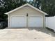 Large two-car garage with white doors and exterior lighting at 211 Hillcrest Dr, Oxford, NC 27565