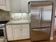 Well-lit kitchen featuring a stainless steel refrigerator and white cabinetry with granite countertops at 211 Hillcrest Dr, Oxford, NC 27565