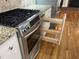 Kitchen featuring stainless steel gas range and custom spice rack with granite countertops and white cabinets at 211 Hillcrest Dr, Oxford, NC 27565