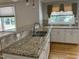 Elegant kitchen with granite countertops, stainless steel sink, and white cabinetry at 211 Hillcrest Dr, Oxford, NC 27565