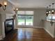 Cozy living space featuring a classic fireplace, large window overlooking the backyard, and hardwood floors at 211 Hillcrest Dr, Oxford, NC 27565
