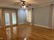 Bright living room featuring hardwood floors, neutral walls, a ceiling fan, and access to the outdoors at 211 Hillcrest Dr, Oxford, NC 27565