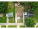 Aerial view of a home nestled among mature trees, showcasing its deck, gravel driveway, and surrounding landscape at 306 Mitchell Ave, Franklinton, NC 27525