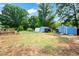A sprawling backyard features multiple storage sheds, set against a backdrop of mature trees, and a wooden deck at 306 Mitchell Ave, Franklinton, NC 27525