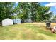 The expansive backyard features various sheds, mature trees, a grill, and a well-kept lawn at 306 Mitchell Ave, Franklinton, NC 27525