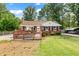 Charming brick ranch home featuring a spacious wooden deck and well-maintained front yard at 306 Mitchell Ave, Franklinton, NC 27525