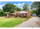 A charming brick home with a spacious front yard, complemented by a wooden deck and beautiful landscaping at 306 Mitchell Ave, Franklinton, NC 27525