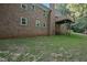 Backyard view of the brick home featuring a wooden deck and green landscaping at 3863 Avents Ferry Rd, Sanford, NC 27330