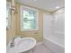 Bright bathroom with a standard tub/shower combo and large window at 3863 Avents Ferry Rd, Sanford, NC 27330