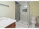 Bright bathroom showcasing a glass shower with gray tiling, white hexagon floors, and modern fixtures at 3863 Avents Ferry Rd, Sanford, NC 27330