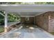 Car port view of brick house with a concrete foundation and two outdoor chairs at 3863 Avents Ferry Rd, Sanford, NC 27330