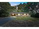 Charming brick home featuring a blue front door, covered carport, and expansive front yard at 3863 Avents Ferry Rd, Sanford, NC 27330