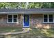 Charming brick home front featuring a blue door, stone walkway, and manicured lawn at 3863 Avents Ferry Rd, Sanford, NC 27330