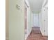 Hallway with wood floors, light green walls, and doors leading to other rooms at 3863 Avents Ferry Rd, Sanford, NC 27330