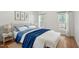 Bright bedroom featuring a bed with white comforter, blue blanket and throw pillows, and matching white nightstand at 428 Grand Pointe Dr, Garner, NC 27529