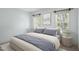 Bedroom featuring blue paint, a bed with gray pillows and comforter, and two windows at 428 Grand Pointe Dr, Garner, NC 27529