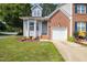 Charming two-story townhome with a brick and siding exterior, a well-manicured lawn, and an attached one-car garage at 428 Grand Pointe Dr, Garner, NC 27529