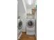 Efficient laundry room with side-by-side washer and dryer and shelving for storage at 428 Grand Pointe Dr, Garner, NC 27529
