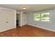 Bright bedroom featuring hardwood floors, two closets, and a window overlooking the yard at 4324 Garland Dr, Raleigh, NC 27606