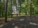 Gravel driveway leads to a single-story brick home surrounded by mature trees at 4324 Garland Dr, Raleigh, NC 27606