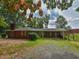 Exterior view of a brick house featuring a carport and a large gravel driveway at 4324 Garland Dr, Raleigh, NC 27606