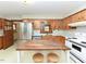 Bright kitchen featuring wood cabinets, stainless steel fridge, island workstation and bright lighting at 4324 Garland Dr, Raleigh, NC 27606