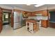 Well-lit kitchen boasts stainless steel appliances, wooden cabinetry, and a central island with seating at 4324 Garland Dr, Raleigh, NC 27606