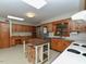 Kitchen featuring wood cabinets, stainless steel fridge, and island workstation and bright lighting at 4324 Garland Dr, Raleigh, NC 27606