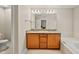 Bathroom featuring double sink vanity with granite counters, tub, and tile floor at 449 Christian Creek Pl, Cary, NC 27519