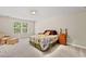 Bright bedroom with a window, floral bedspread, a reading chair and neutral walls at 449 Christian Creek Pl, Cary, NC 27519