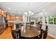 Dining room with wood floors and a dark wood table with seating for six, open to the kitchen and living room at 449 Christian Creek Pl, Cary, NC 27519