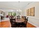 Dining room featuring a dark wood table with seating for six, with adjacent living room and access to the backyard at 449 Christian Creek Pl, Cary, NC 27519