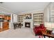 Inviting living room featuring a fireplace with a TV, built-in shelving, comfortable chairs, and access to kitchen at 449 Christian Creek Pl, Cary, NC 27519