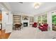 Inviting living room with fireplace, TV, built-in shelving, comfortable chairs, and access to an outdoor area at 449 Christian Creek Pl, Cary, NC 27519