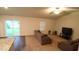 Spacious living room with a sliding glass door, plush carpet, and plenty of natural light at 50 Atlas Dr, Youngsville, NC 27596